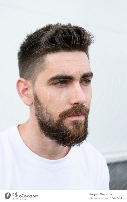 Portrait of a very handsome Caucasian man with a beard and white shirt. portrait young face guy person smile smiling people isolated happy men expression casual