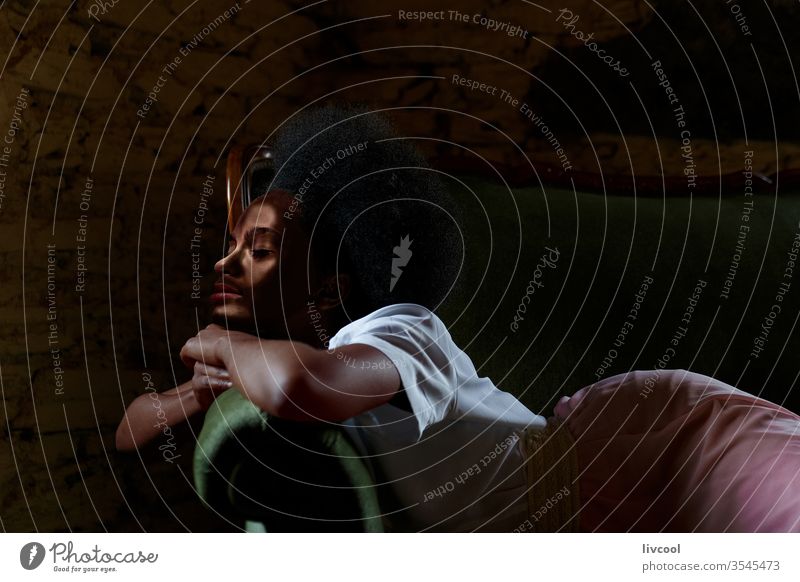 afro woman lying on a green velvet sofa during the quarantine by covid-19 living room nostalgically waiting to get out green sofa sitting room home house seat