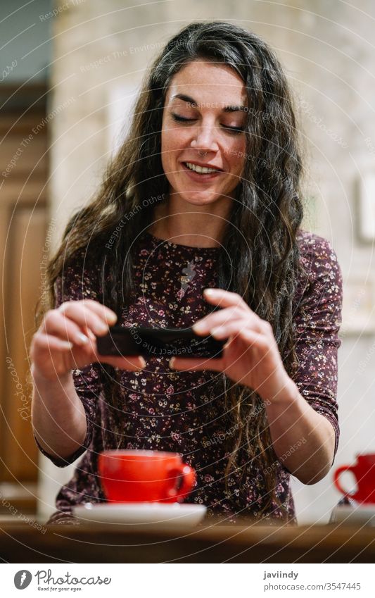 Young woman with some gray hair using smartphone in a cafe. coffee smart phone caucasian white photograph person cup girl adult casual female beautiful fun