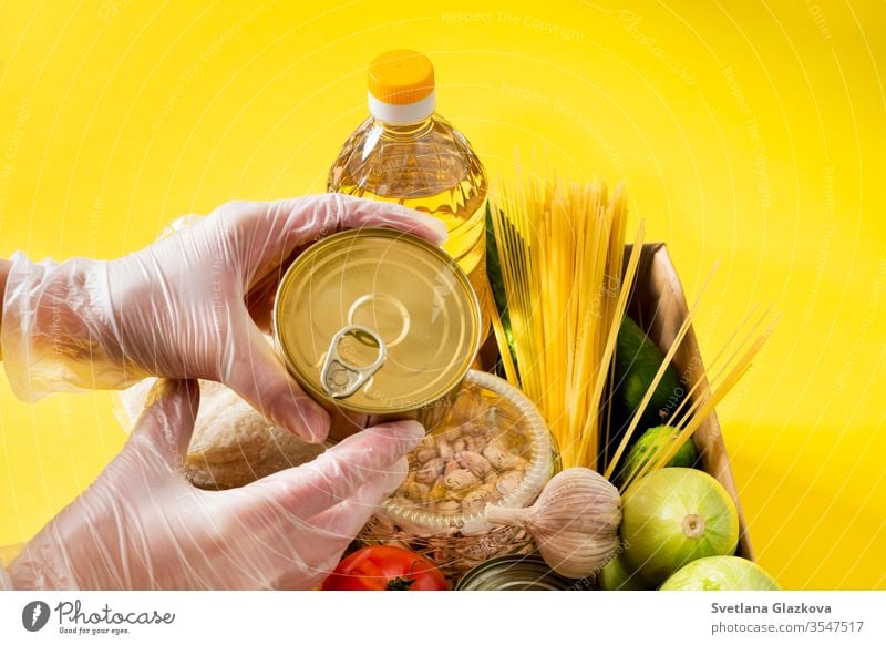 Donation. Food supplies crisis food stock for quarantine isolation period on yellow background. Rice, peas, cereals, canned food, oil, vegetables, mask, sanitizer. Food delivery, coronavirus.