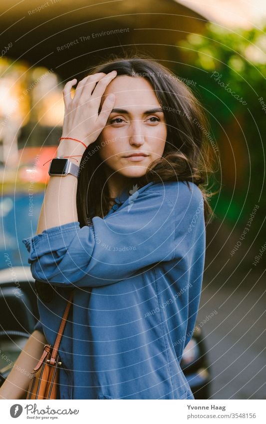 Woman pulls a strand of hair from her face Downtown Town Summer urban Paris Charming Shadow Sunglasses sunny Eyeglasses fashion accessories Bag Exterior shot