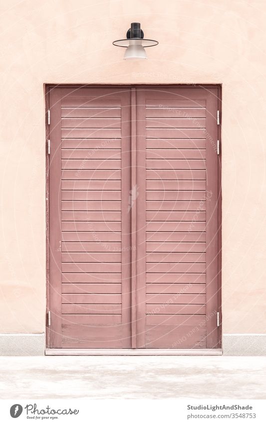 Pink building with a wooden door entrance pink red pastel closed house home lamp streetlamp streetlight exterior city town urban Europe European Stockholm