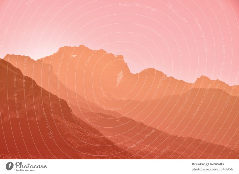 Sunset or sunrise aerial perspective mountain range landscape with clear sky copy space Mountain ridge pink orange yellow warm toned sunset dusk colors vivid