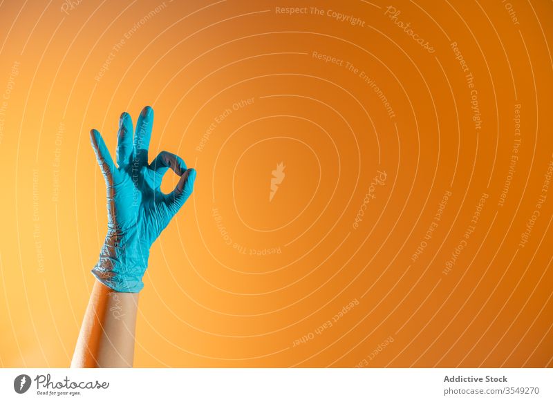 Crop person in rubber glove showing ok sign gesture clean gesticulate concept horn symbol demonstrate protect hygiene healthy domestic housework household