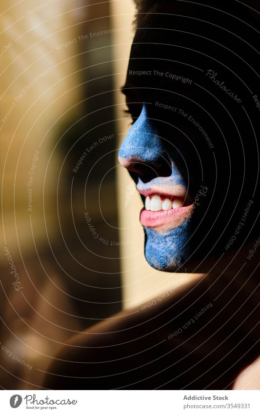 Crop smiling woman with blue clay mask applied on face toothy smile skin care facial beauty happy content sunlight dreamy thoughtful contemplate calm tranquil