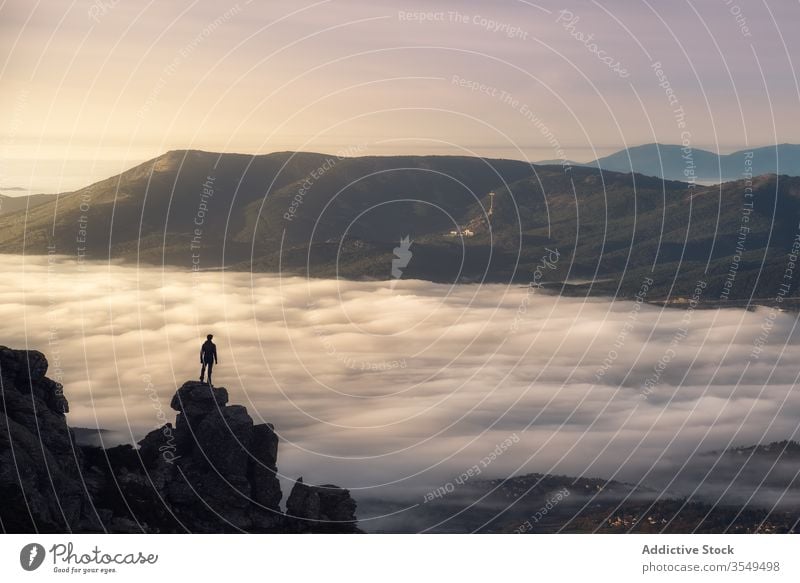 Traveler standing on top of rocky mountain cloud fog travel landscape nature hike cliff peak freedom inspiration valley tourist magnificent morning adventure