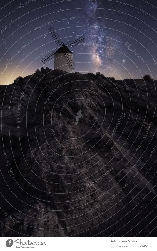 Rocky hill with dutch windmill at starry night landscape milky way mountain rock sky spectacular dark scenery magnificent evening amazing scenic galaxy universe