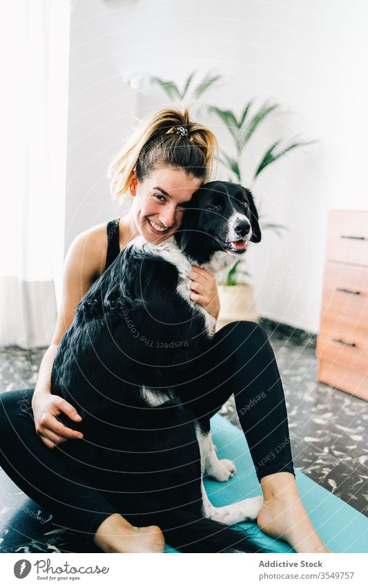 Woman having fun with dog during yoga session at home woman smile companion friend hug together owner female purebred practice pet animal lifestyle canine