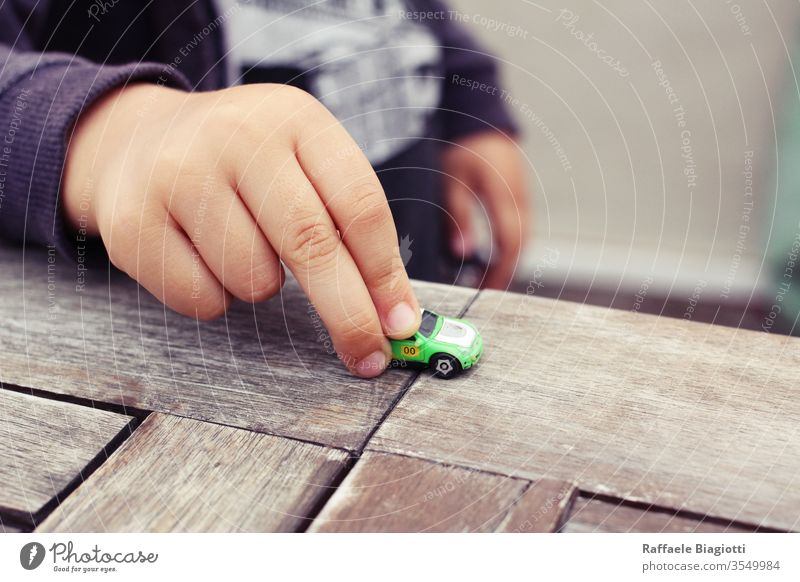 my son is playing with his favourite car , the micro machine that it belonged to me , an evergreen smile home lovely baby playful happiness imagination park