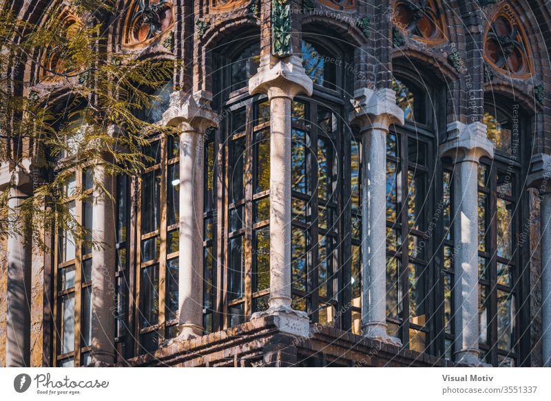 Modernist enclosed balcony of Golferichs House in Barcelona ornament old building tree branch sunny column window barcelona spain corner aged architecture