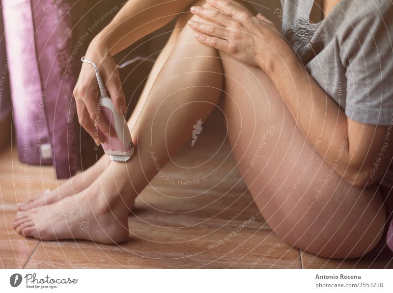 Woman shaves in the privacy of her bedroom next to a window at home beauty care caucasian copy space cropped day daylight depilation horizontal hygiene indoors