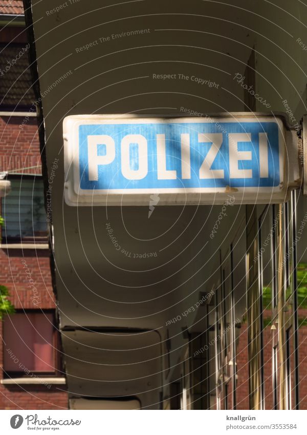 Illuminated sign POLICE above the entrance to a police station Police Force Agency Signs and labeling Exterior shot Day Light and shadow Entrance Deserted