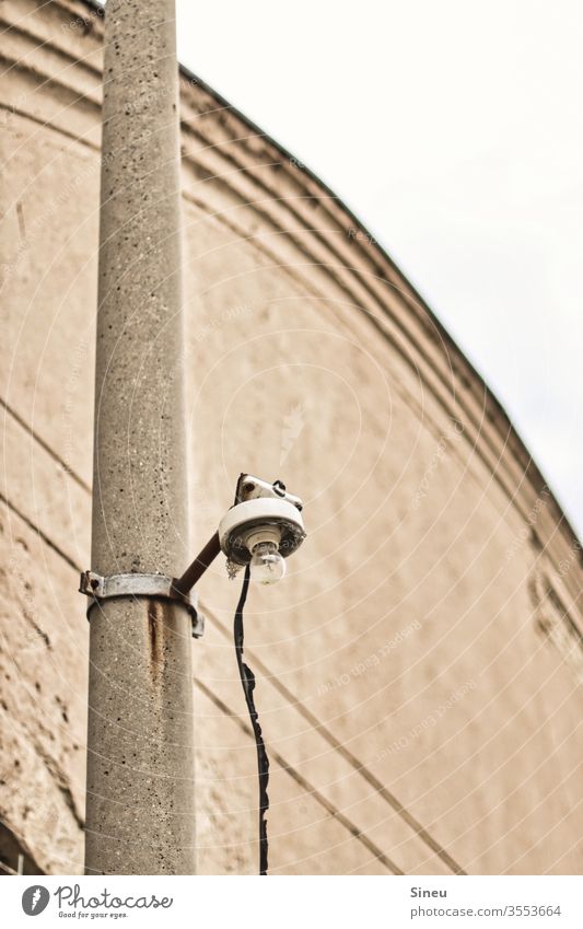 Lonely lantern on concrete pile Lantern lone lantern Electric bulb Concrete Concrete pile Cable stream power supply Light Industrial plant