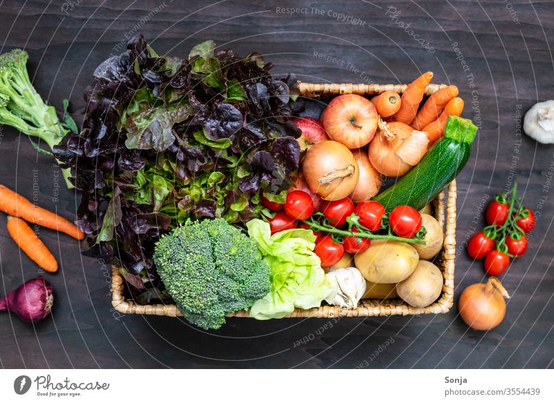 Fresh regional fruit and vegetable box on a brown wooden table, top view Vegetable Organic produce Vegetarian diet Nutrition Healthy Fruit- or Vegetable stall