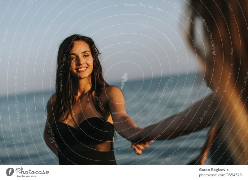 Young women having fun at summer vacations on the beach beautiful two people attractive sea lifestyle happy water friends young female fashion friendship ocean