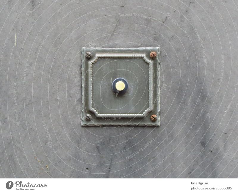 Old fashioned square doorbell in grey with white bell button on grey background Bell Living or residing Square metal plate Signs and labeling Wall (building)