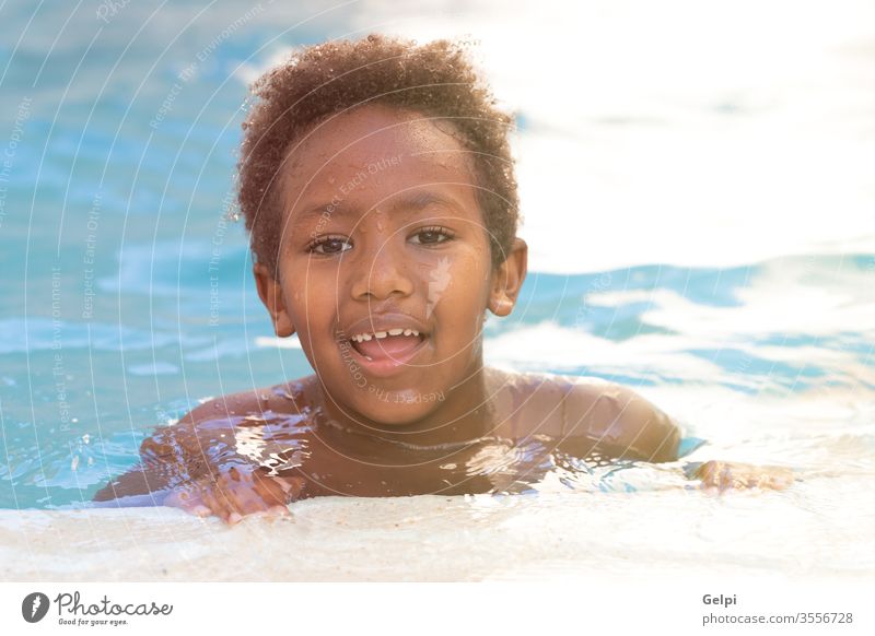 Little african child splashing out in the pool water boy summer black young childhood person people small youth play beautiful blue swim playful vacations