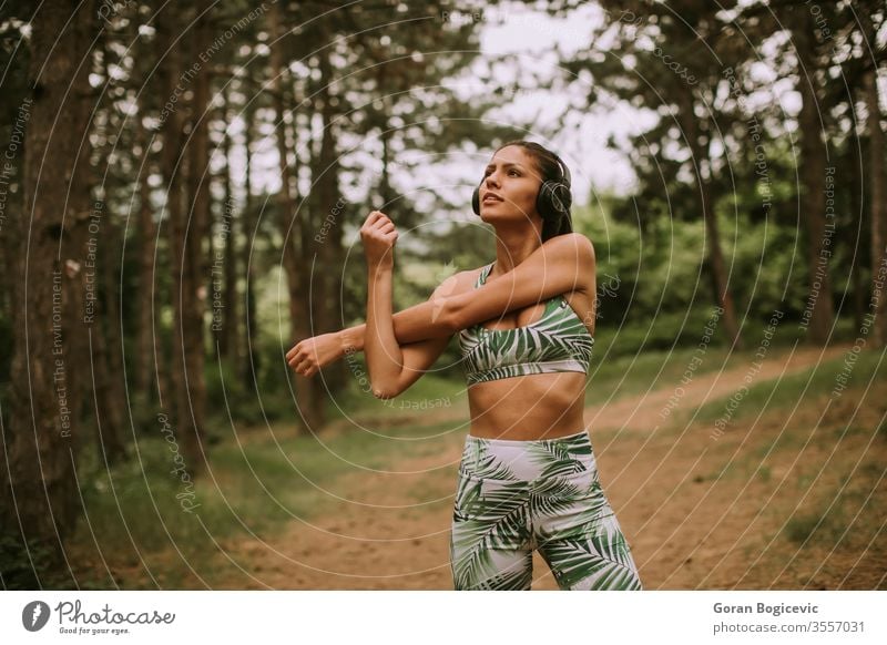 Young woman stretching and breathing fresh air in middle of forest while exercising young exercise fitness lifestyle workout healthy person adult female sporty