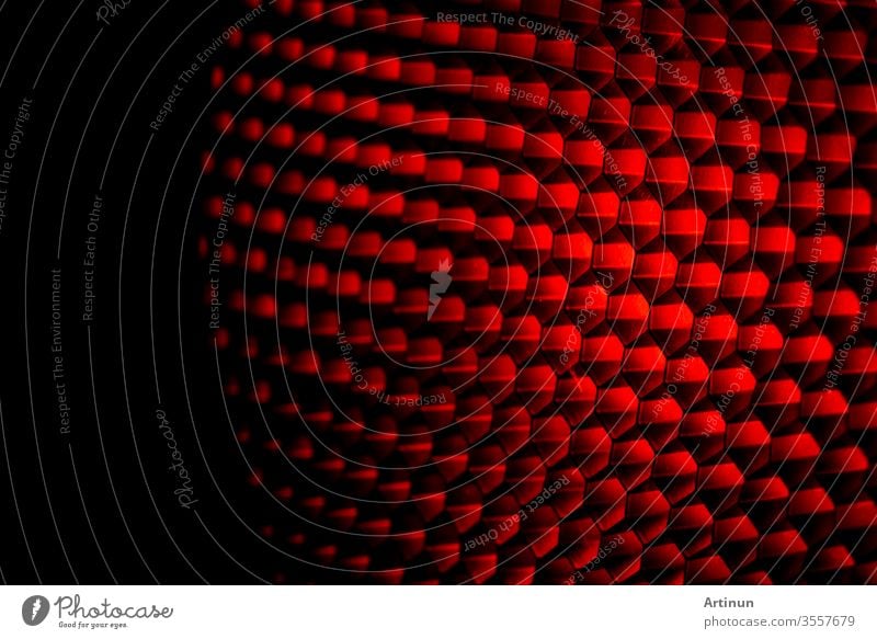 Closeup honeycomb grid texture with red light. Red and dark metal hexagon shaped pattern abstract background. Light modifier equipment. Metal honeycomb. Futuristic pattern. Honey grid cells network.