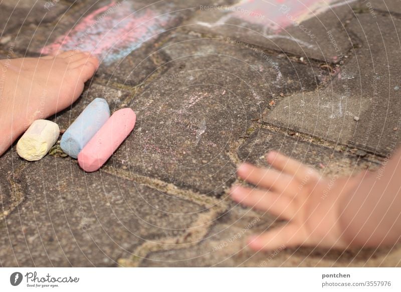 Two children paint with street chalk. Children's hand and foot game Painting (action, artwork) creatively feet hsbd variegated colors Creativity Infancy