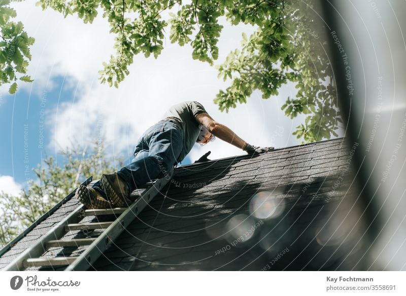 home owner climbing up rooftop on ladder aluminum architecture authentic building cleanup construction dangerous elevated estate finishing touches house