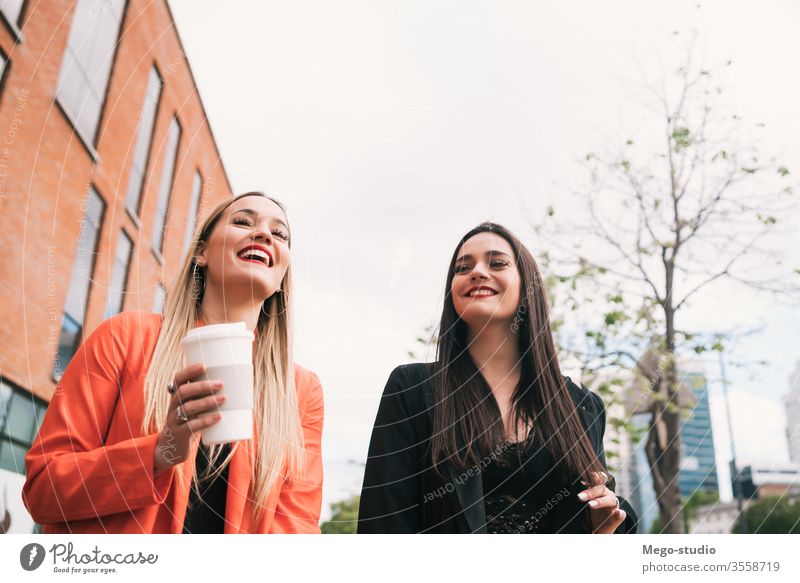 Two young friends walking together outdoors. two street city smiling pretty talking girlfriend town concept view style travel weekend looking enjoyment outside