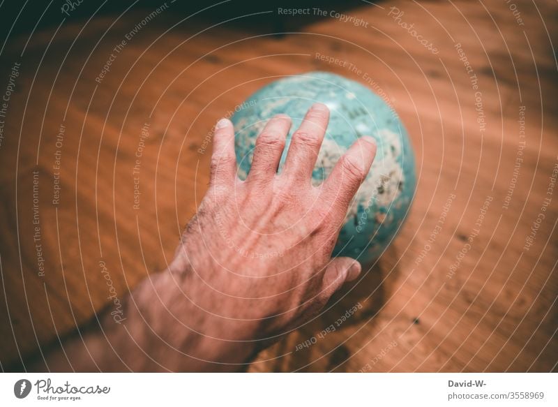 reach for the world - hand reaches for a globe by hand Grasp takes effect. Megalomania Globe Man corona improve Target Geography Around-the-world trip