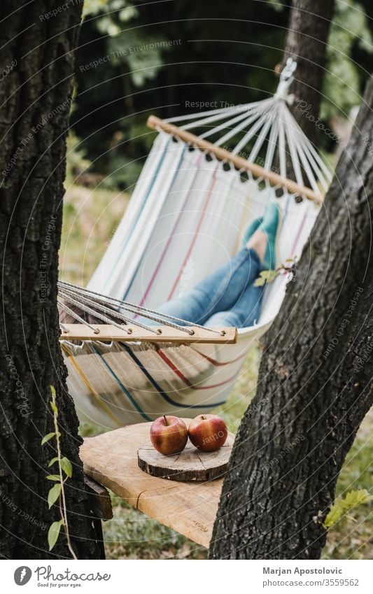 Young woman relaxing in the hammock in nature adult alone backyard calm carefree casual comfortable countryside day dream easy enjoy female forest furniture