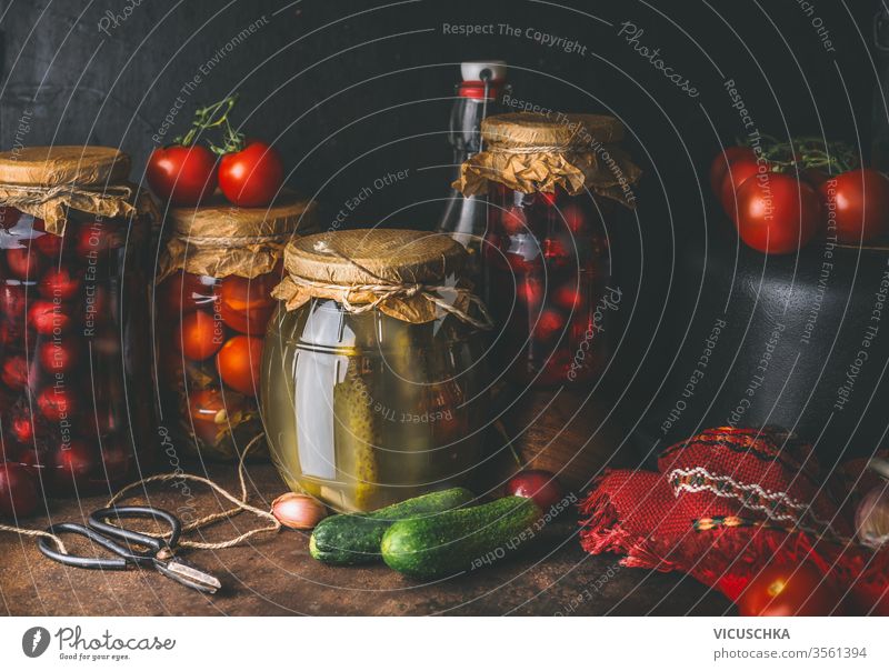 Harvest preserving concept. Jars with pickled vegetables and fruits on dark rustic kitchen table. Canned food for winter season. Canning  of harvest. preserve