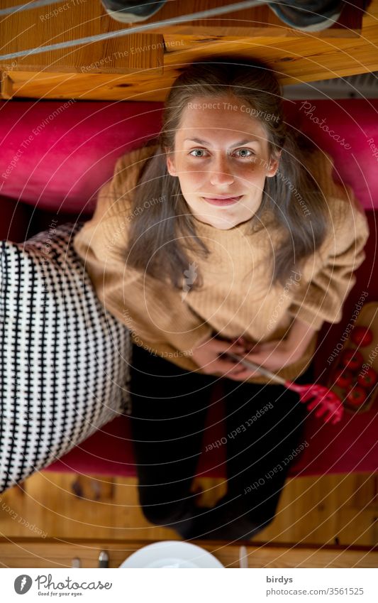 Young woman sitting on a red sofa looks up into the camera and smiles Woman Looking into the camera Sit Dinner table hunger Face Feminine already portrait