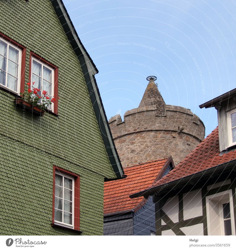 historical buildings with shingles, half-timbered and in the background a round tower in front of a blue sky built Manmade structures Facade wooden shingles