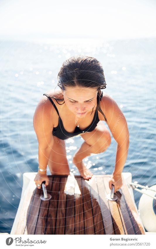 Young woman get on the yacht on sea at sunny day adult alone attractive beautiful blue board boat calm caucasian cruise cruising deck female happy holiday