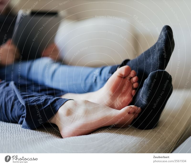 Children's feet, barefoot and with socks, lying on the sofa Barefoot Legs children Lie Playing Reading Sofa Infancy Friendship togetherness in common Together