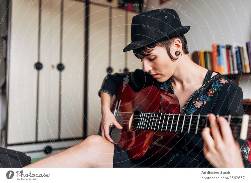 Calm woman playing guitar in bedroom music acoustic instrument calm tranquil trendy female melody sound sit hobby musician song relax style tune lady young