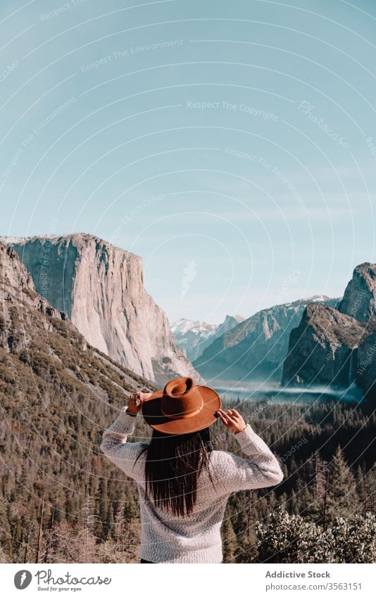 Traveler enjoying majestic mountain landscape woman travel cliff rock national yosemite park forest hill female hat picturesque scenery granite sunny blue sky