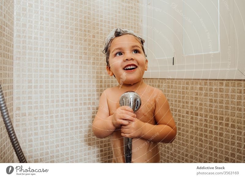 Cute boy singing in shower at home bathroom little foam smile child cute having fun kid cheerful content delight positive glad happy hygiene wet hair wash