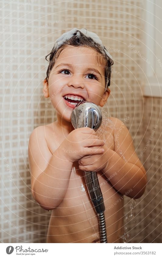 Cute boy singing in shower at home bathroom little foam smile child cute having fun kid cheerful content delight positive glad happy hygiene wet hair wash