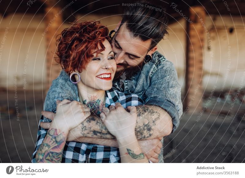 Happy young couple embracing near weathered building love embrace happy hipster street shabby together hug relationship tattoo boyfriend girlfriend affection