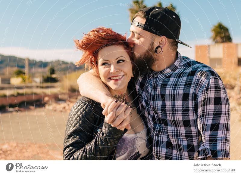 Happy young couple embracing near weathered building love embrace happy hipster street shabby together hug relationship tattoo boyfriend girlfriend affection