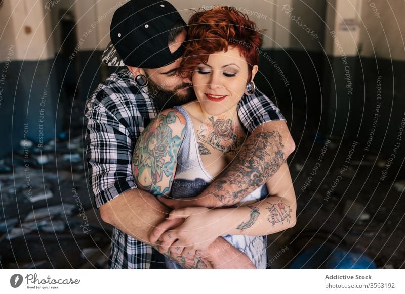 Happy young couple embracing near weathered building love embrace happy hipster street shabby together hug relationship tattoo boyfriend girlfriend affection