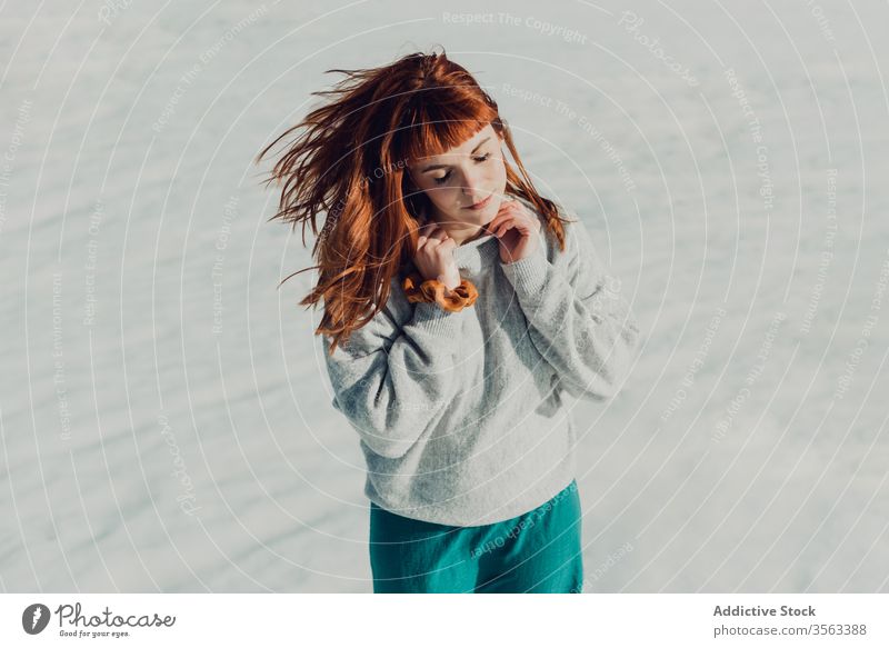 Sensual woman with red hair standing in snow field style trendy sensual redhead young nature attractive female ginger fashion modern charming elegant makeup