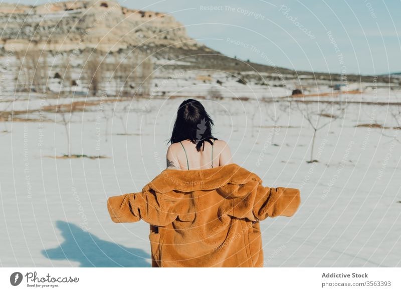 Young woman in fur coat and lingerie standing in snowy field sensual nature winter brunette confident female trendy young slim style fashion lady attractive