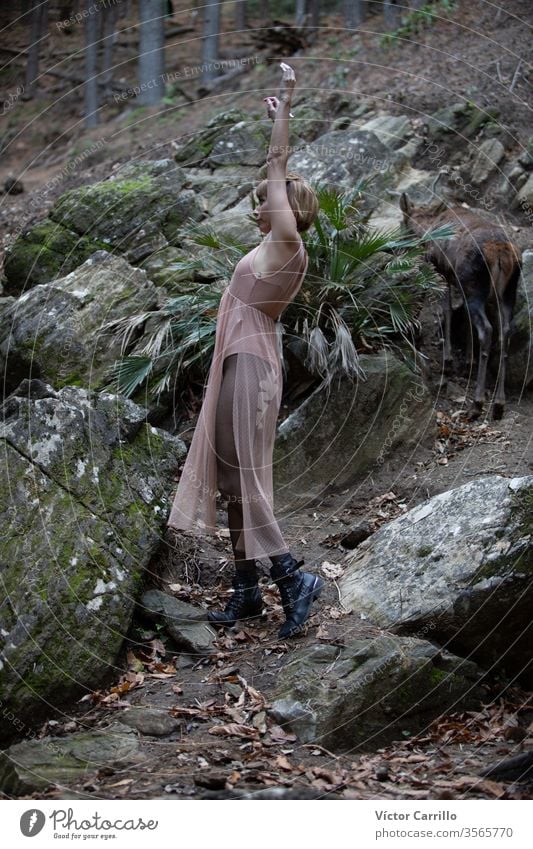 A young beautiful boho girl dancing in a a forest background spirit glamour ethnic pretty free standing lady trees romantic wood posing woman person tribal