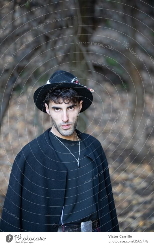 A young stylish young man with a hat in a forest environment real people one man only countryside leaves warm relaxed outdoors pose outside looking confident