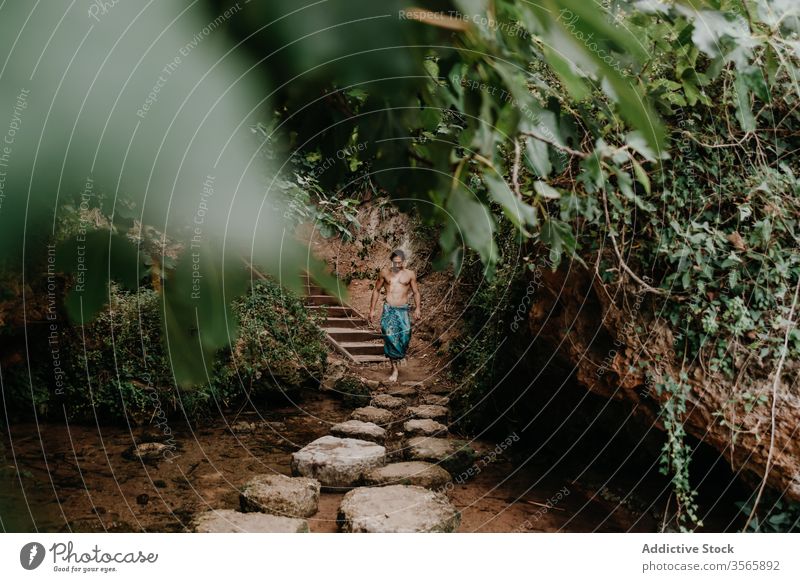 Man in traditional pants walking in forest man spirit nature ethnic tree garden shirtless male muscular naked torso barefoot harmony tranquil vitality balance