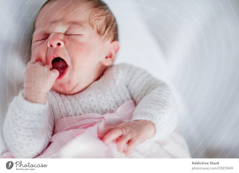 Newborn girl yawning in crib newborn baby cot adorable lying sleep cute cozy dress infant innocent child rest nap relax babyhood tranquil serene peaceful calm