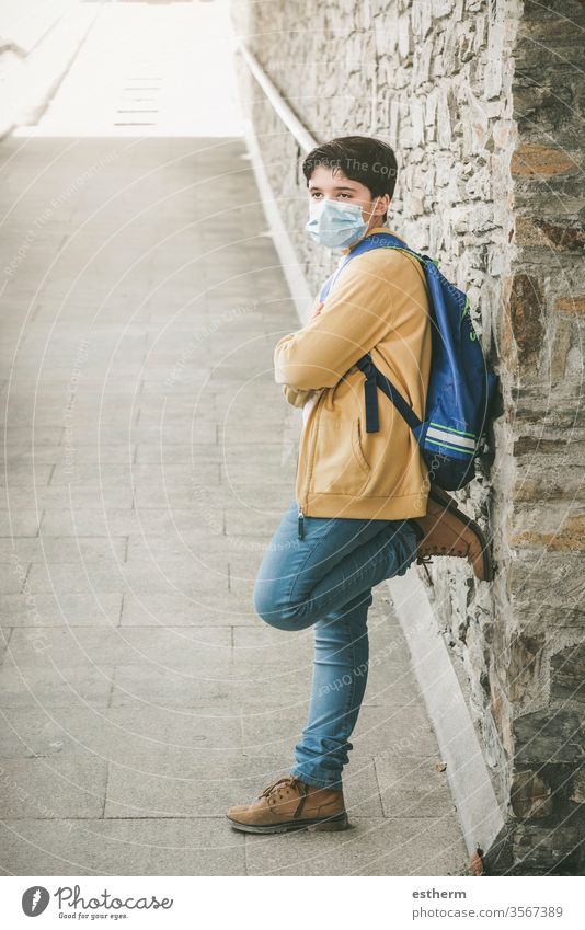 kid with medical mask and backpack waiting at the school door coronavirus child epidemic covid-19 student pandemic quarantine back to school city schoolboy