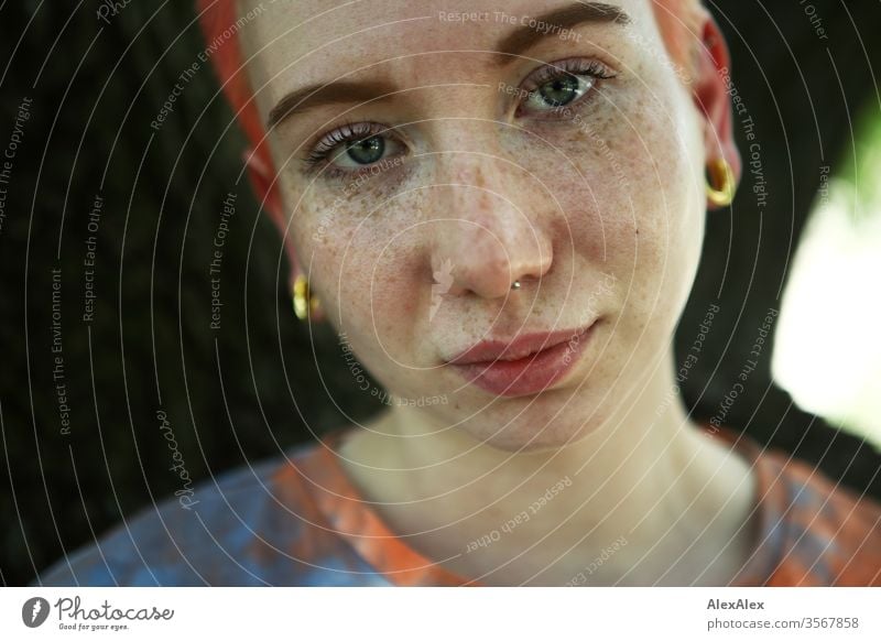 Portrait of a young woman in front of a tree Woman 18-25 years already Slim Freckles Red-haired Jewellery Piercing tattooing Face Fair-skinned Short-haired