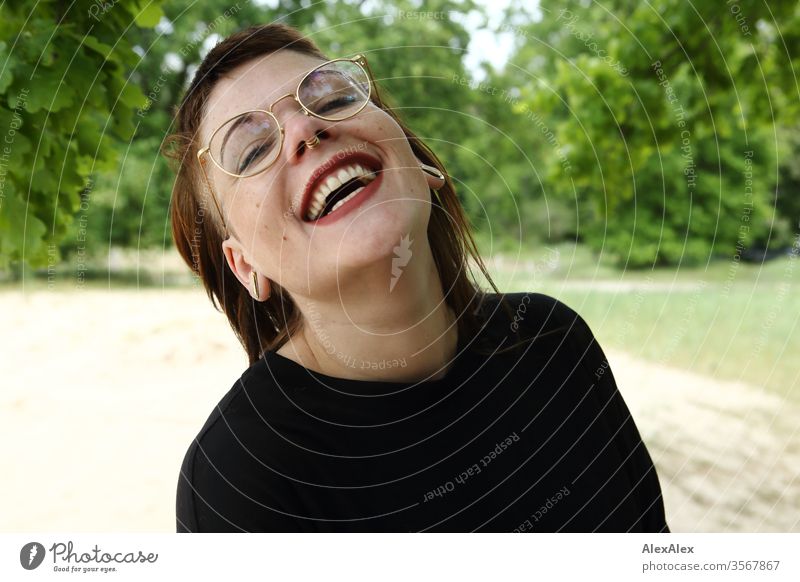 Portrait of a laughing young woman in the park Woman Youth (Young adults) already Strong Alternative great Piercing Skin Intensive Looking look watch Stand Slim