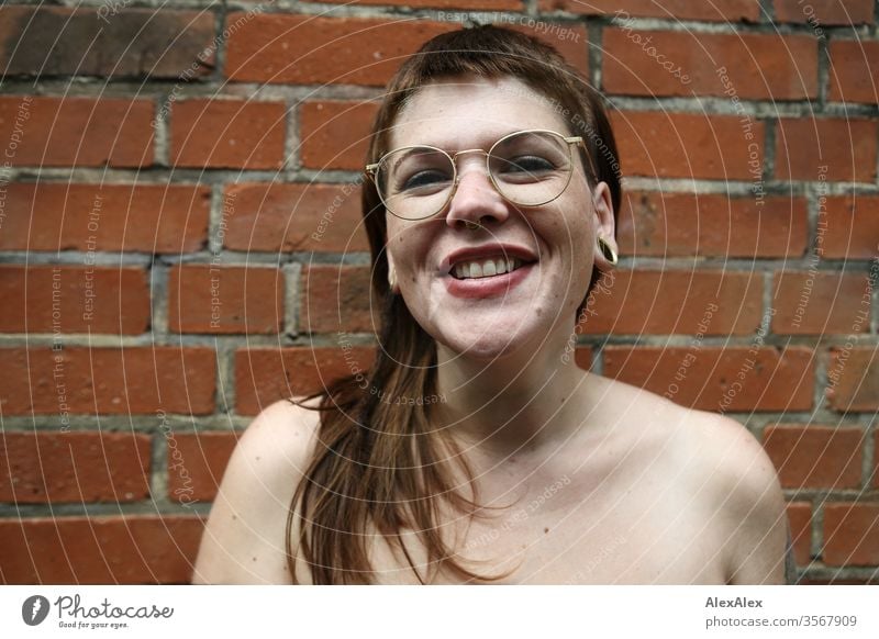 Portrait of a laughing young woman in front of a brick wall Woman Youth (Young adults) already Strong Alternative great Piercing Skin Intensive Looking look